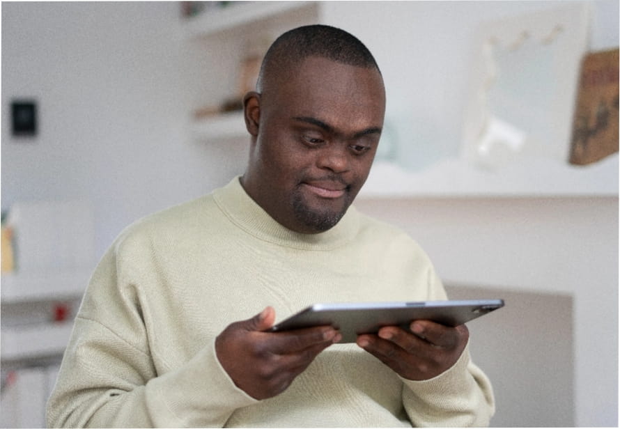 a man with downs syndrome holding a tablet